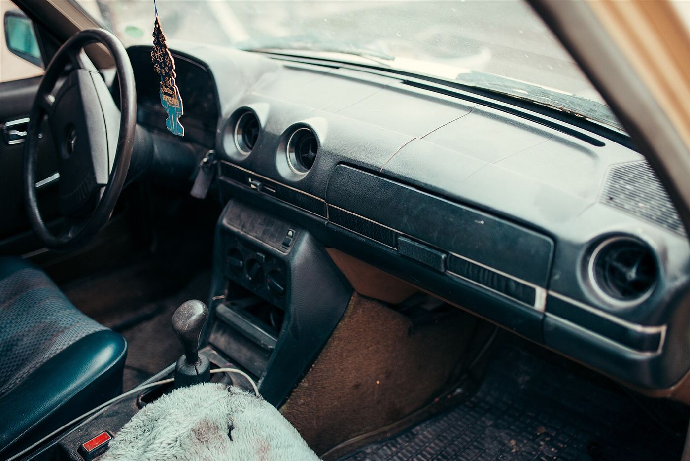 Sun-worn car dashboard and interior with faded and cracked surfaces