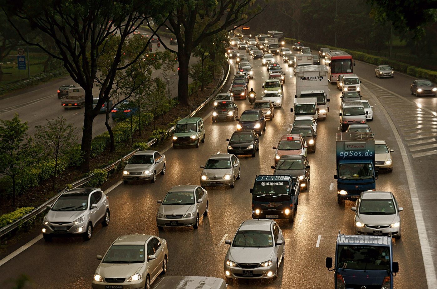 Heavy stop-start traffic on a multi-lane road at dusk
