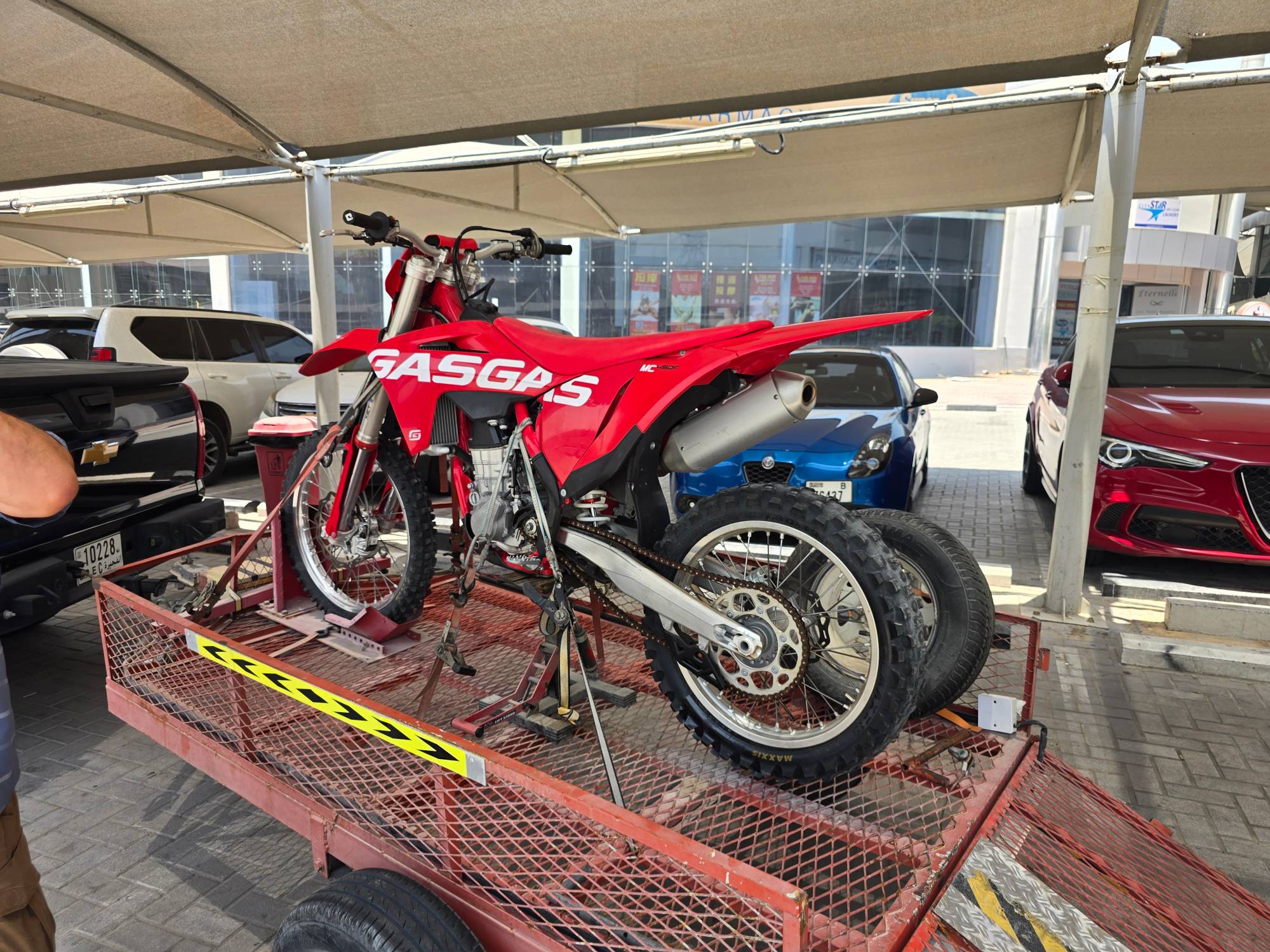 Red GasGas MC450F dirt bike strapped to a trailer ready for servicing