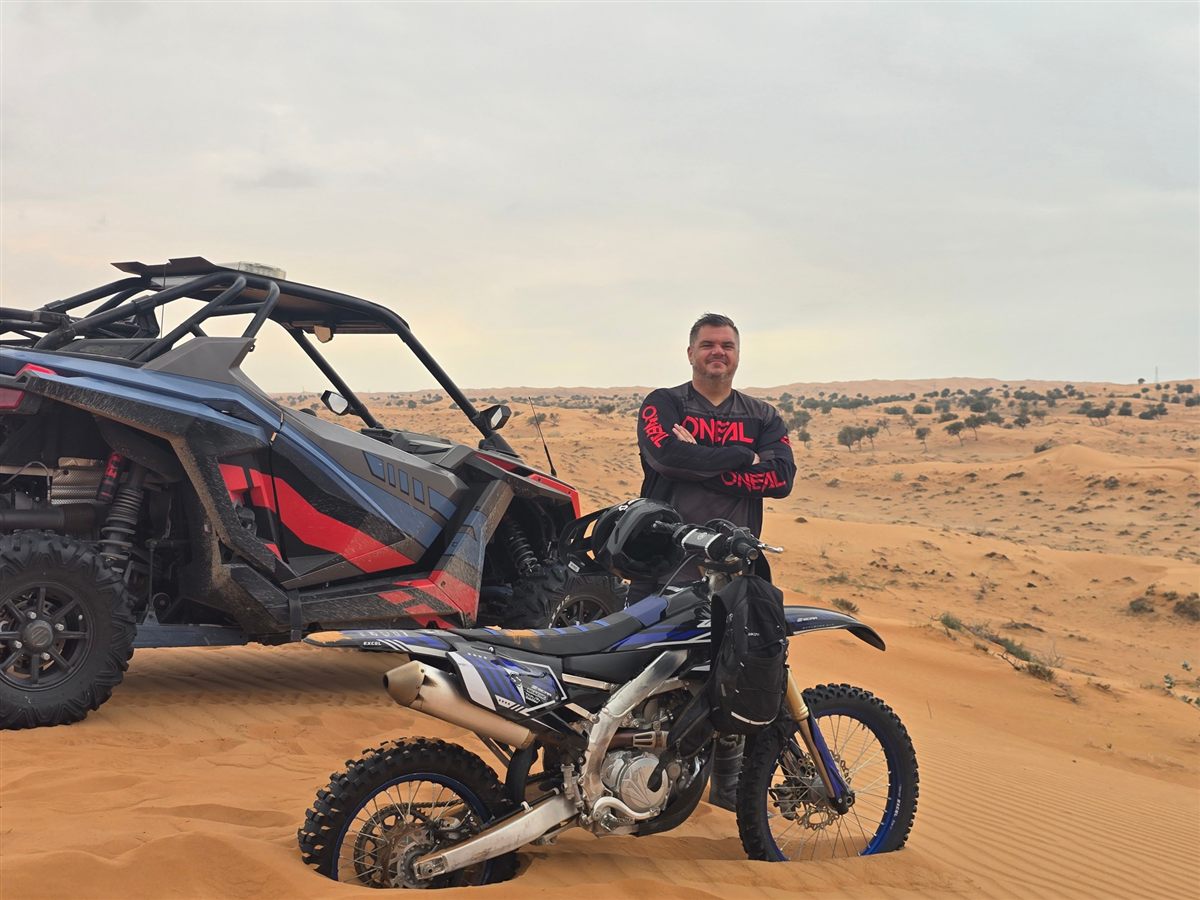 Chris Caley, Operations Director at Western Auto And Marine, with a Polaris RZR and a Yamaha dirt bike in the Ras Al Khaimah desert